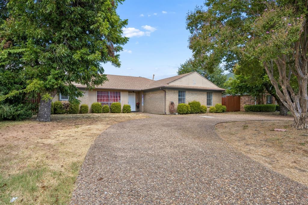 1701 East Spring Valley Road Richardson, TX 75081 - Photo 2 of 28 Brick exterior with a gabled roof and mature trees flanking the property