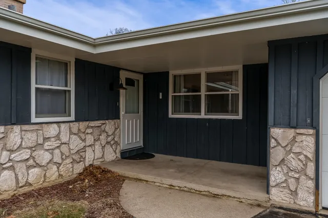a living room with furniture a flat screen tv and a floor to ceiling window