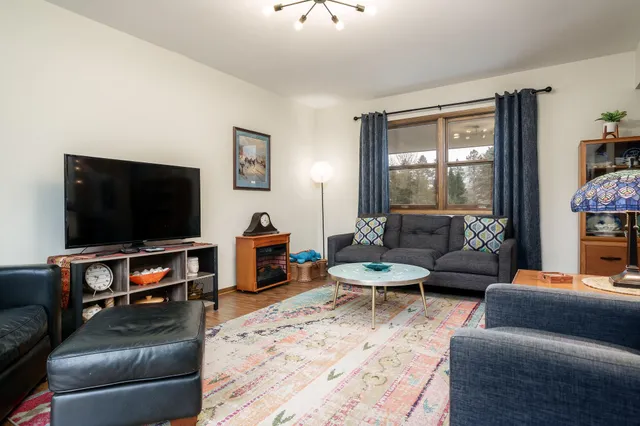 a kitchen with stainless steel appliances a stove a sink a refrigerator white cabinets and wooden floor