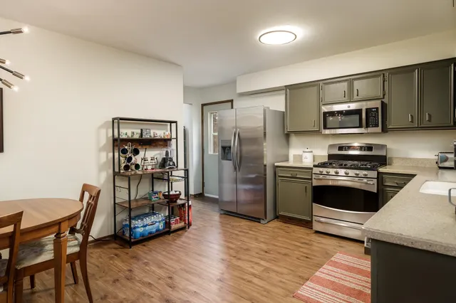 a kitchen with stainless steel appliances granite countertop a stove a sink and a microwave