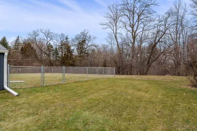 a view of a house with backyard and trees