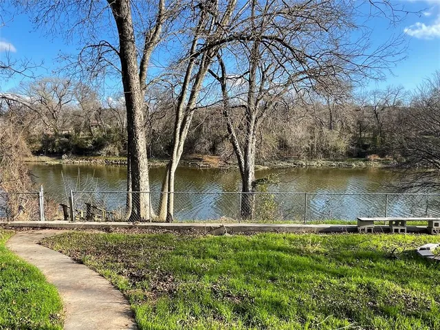 a view of a lake in between the two trees
