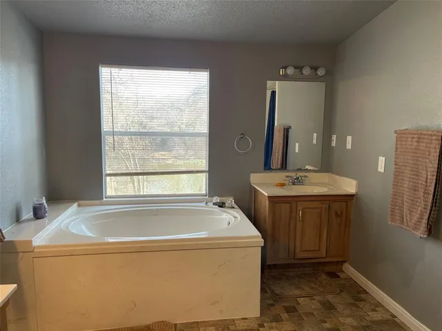 a bathroom with a tub sink and mirror
