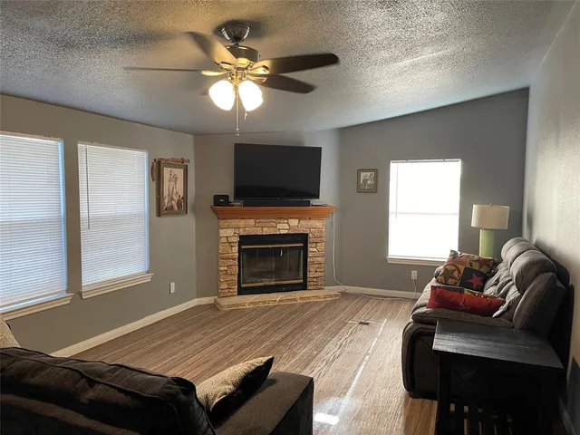 a living room with furniture a flat screen tv and a fireplace