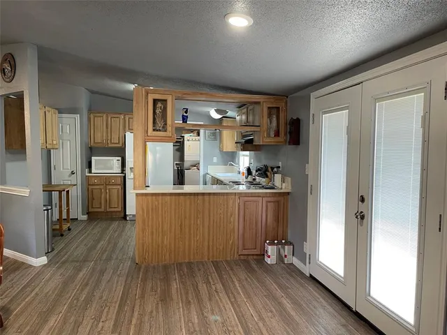 a kitchen with stainless steel appliances a refrigerator and wooden floor