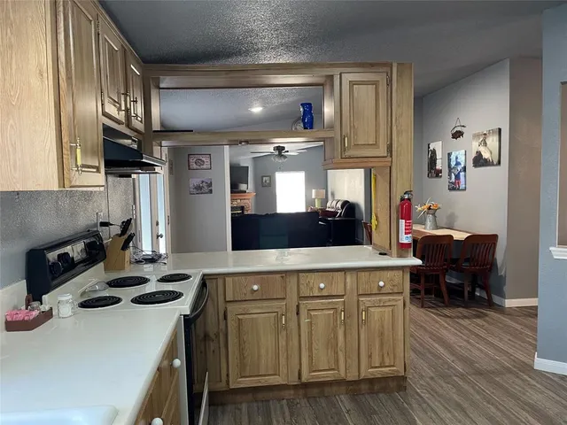 a kitchen with a stove cabinets and wooden floor