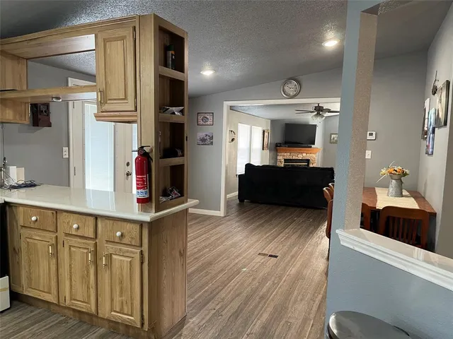a kitchen with cabinets and wooden floor