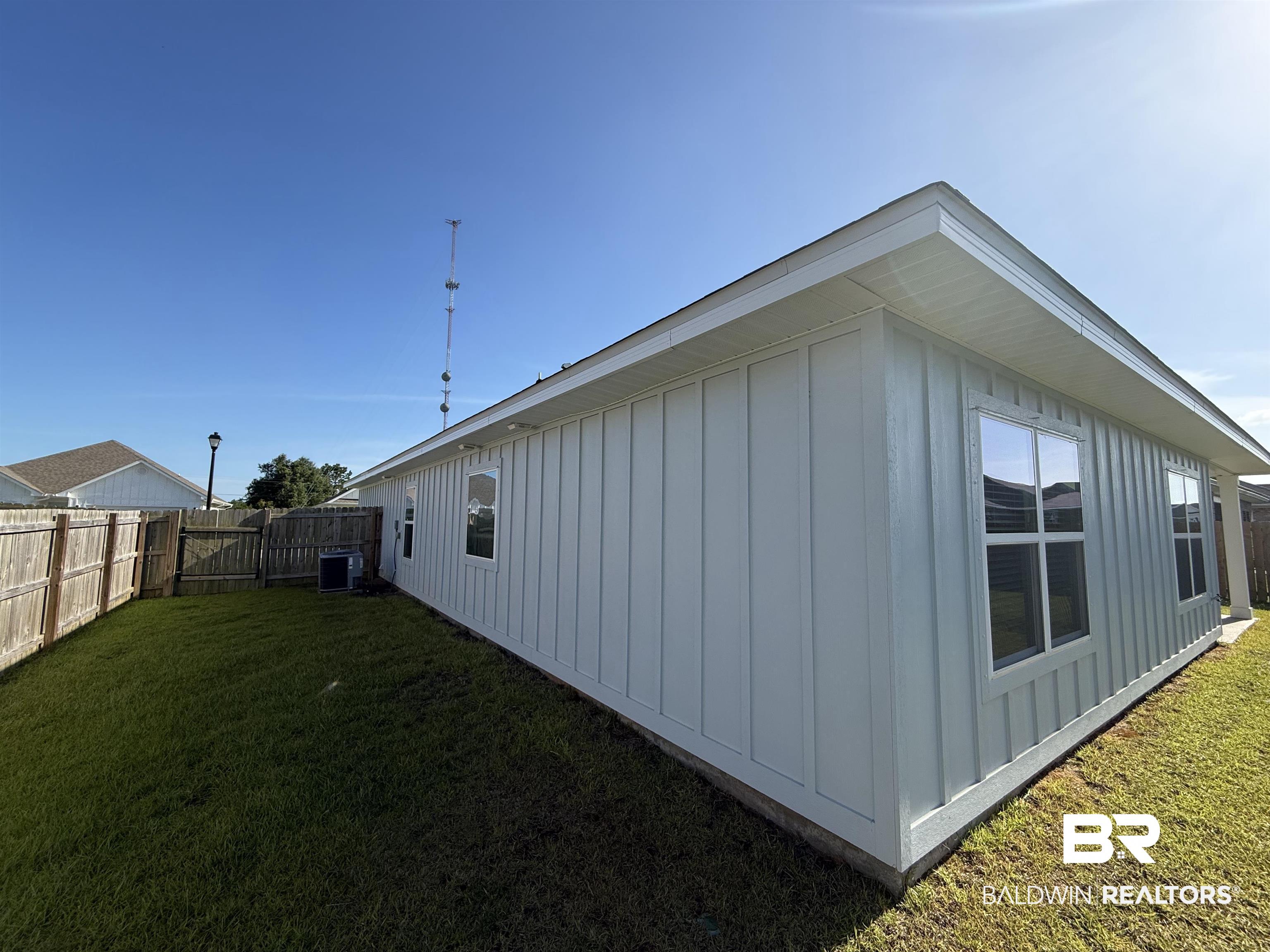 23247 Lieutenant Avenue Foley, AL 36535 - Photo 41 of 47 White board-and-batten siding with multiple windows and a neutral roofline