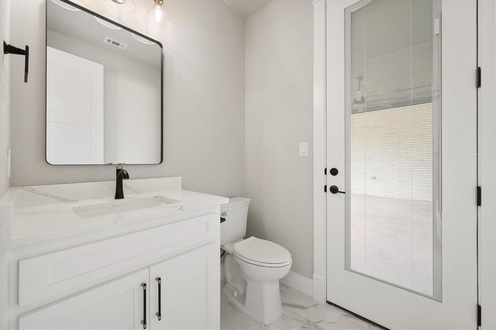 6610 Waggoner Way Midlothian, TX 76065 - Photo 31 of 40 Bathroom featuring a white vanity with a rectangular sink, a black faucet, and a framed mirror