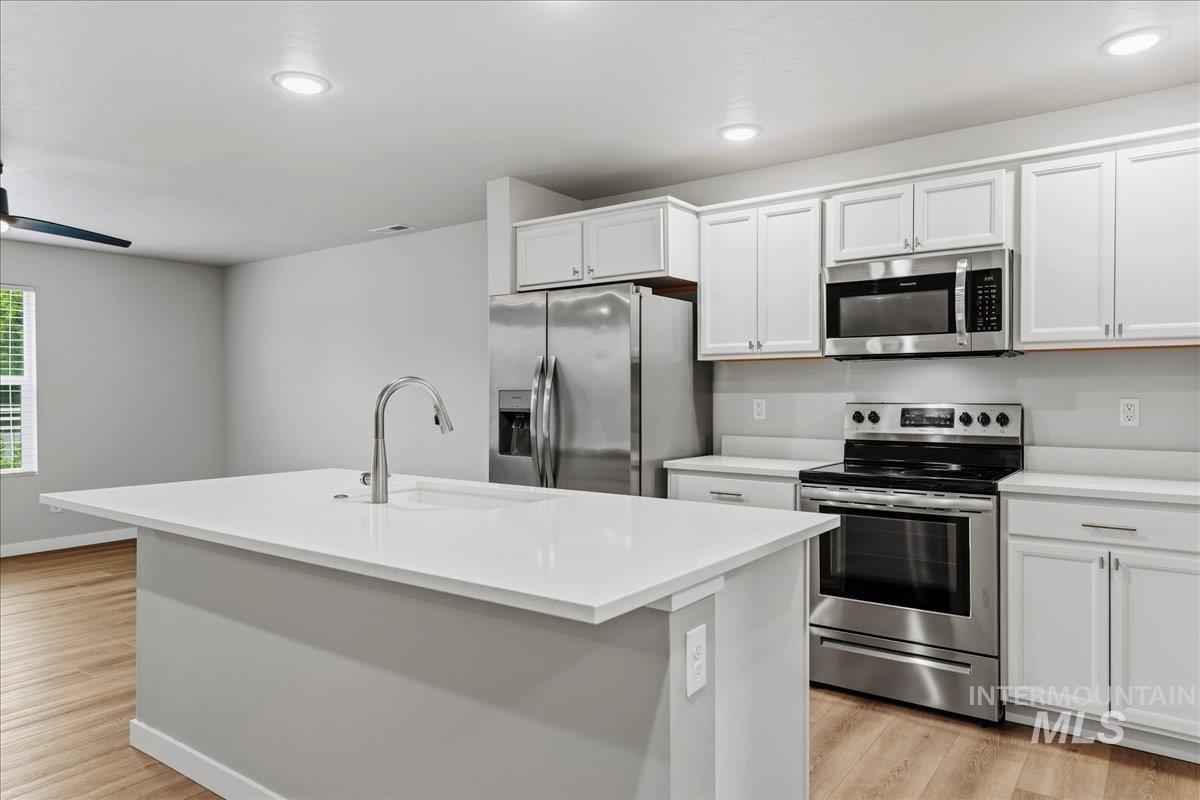 12475 West Victory Road Boise, ID 83709 - Photo 12 of 26 Contemporary kitchen featuring a large center island with an undermount sink and gooseneck faucet