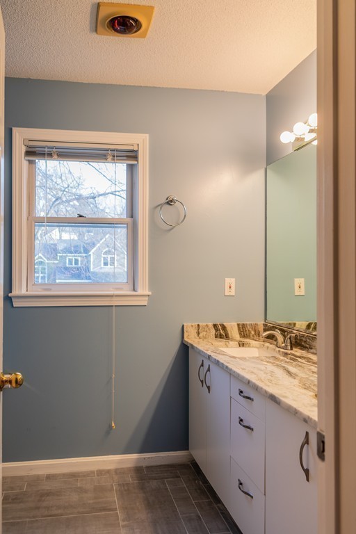 85 Bishops Forest Drive, Unit 85 Waltham, MA 02452 - Photo 18 of 32 a bathroom with a granite countertop sink a mirror and a shower