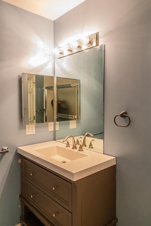 85 Bishops Forest Drive, Unit 85 Waltham, MA 02452 - Photo 20 of 32 a bathroom with a sink and a mirror