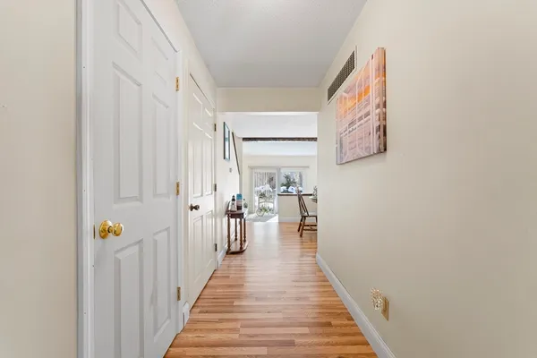 a view of a hallway with wooden floor and staircase