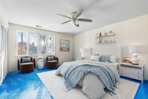 a bedroom with a bed couch and window