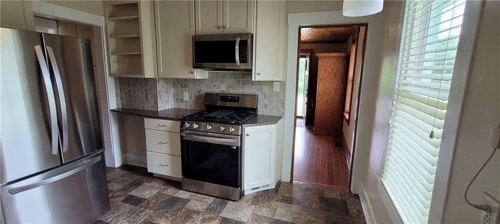 446 Eagle Mill Road Butler, PA 16001 - Photo 14 of 27 a kitchen with stainless steel appliances granite countertop a refrigerator a stove a microwave and a window with wooden floor