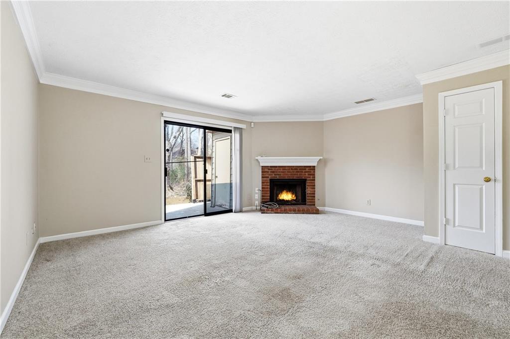 136 Sterling Court Alpharetta, GA 30004 - Photo 10 of 25 an empty room with a fireplace and windows