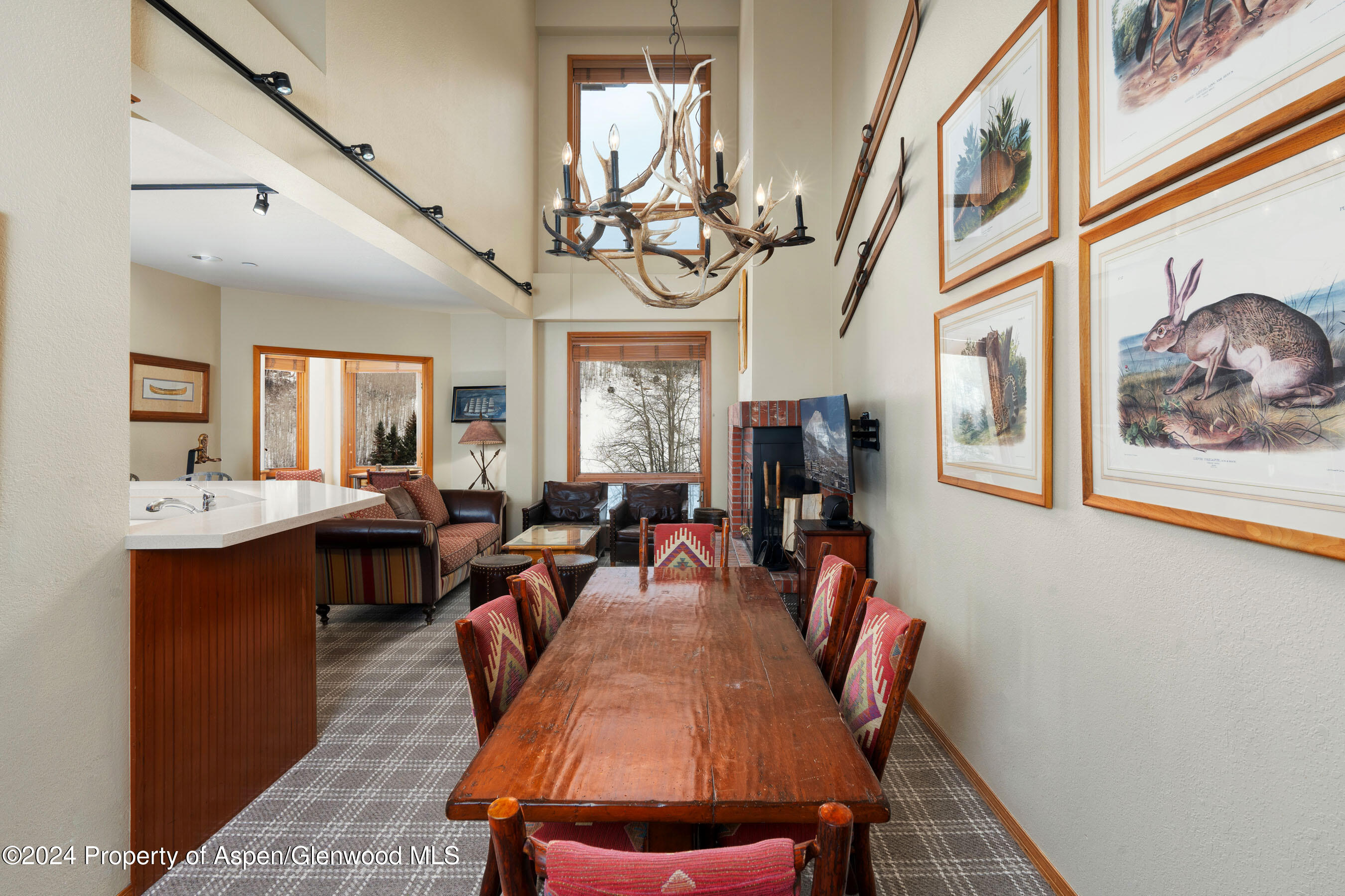 476 Wood Road, Unit 41 Snowmass Village, CO 81615 - Photo 5 of 29 a view of a dining room with furniture a chandelier and wooden floor