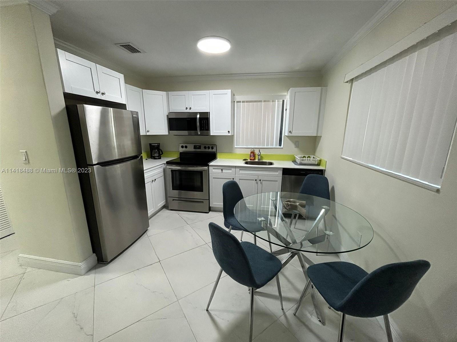 46 Northwest 35th Street Miami, FL 33127 - Photo 4 of 17 a kitchen with stainless steel appliances a refrigerator stove microwave and sink