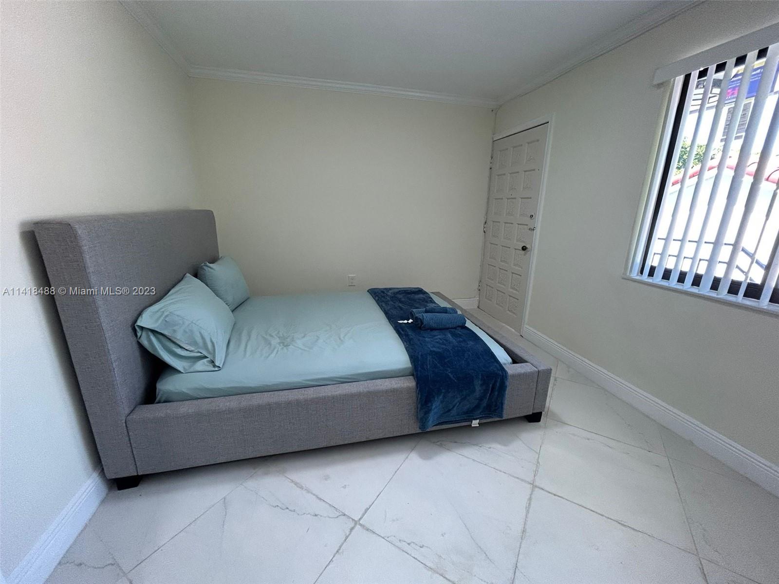 46 Northwest 35th Street Miami, FL 33127 - Photo 10 of 17 a living room with a couch and a window