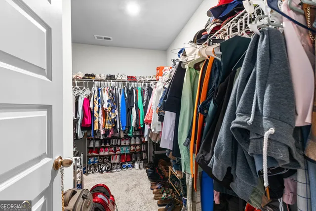 a view of walk in closet with clothes