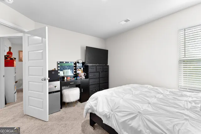 a bedroom with a bed and a flat screen tv