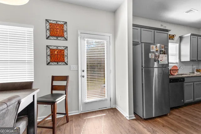 a kitchen with stainless steel appliances wooden floor and a window