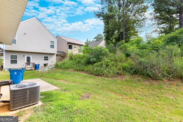 a view of a house with backyard and sitting area