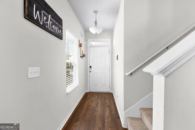 a view of a hallway with wooden floor and staircase