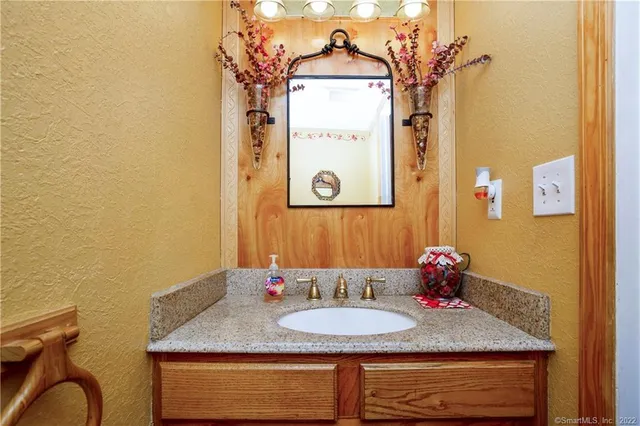 a bathroom with a granite countertop sink and a mirror
