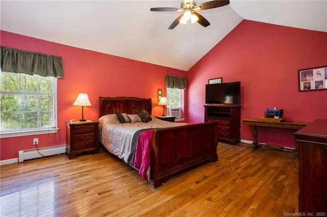 a bedroom with a bed dresser and a flat screen tv