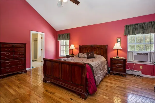 a bedroom with a bed and wooden floor