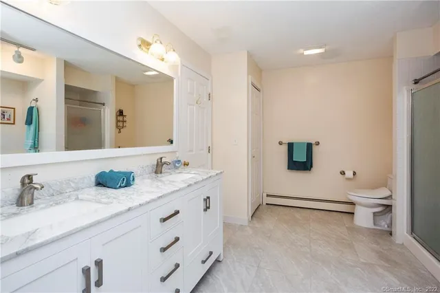 a bathroom with a double vanity sink toilet and mirror