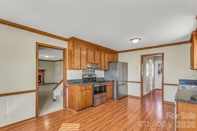 a kitchen with granite countertop wooden cabinets and stainless steel appliances