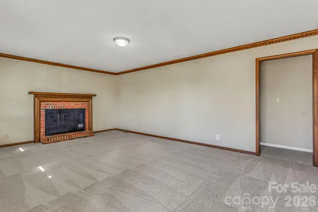 an empty room with windows and fireplace