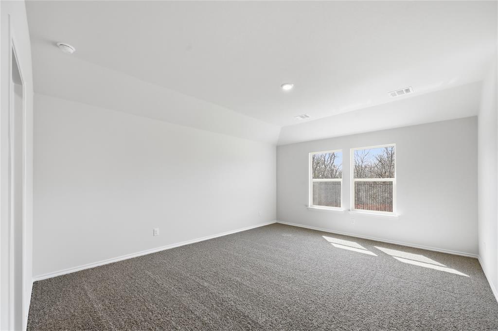 1907 Reveille Way Terrell, TX 75160 - Photo 5 of 6 Spacious room featuring neutral carpeting, white walls, two large windows, recessed lighting, and a tray ceiling