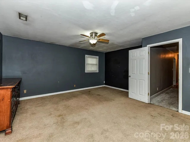 a view of an empty room with a ceiling fan