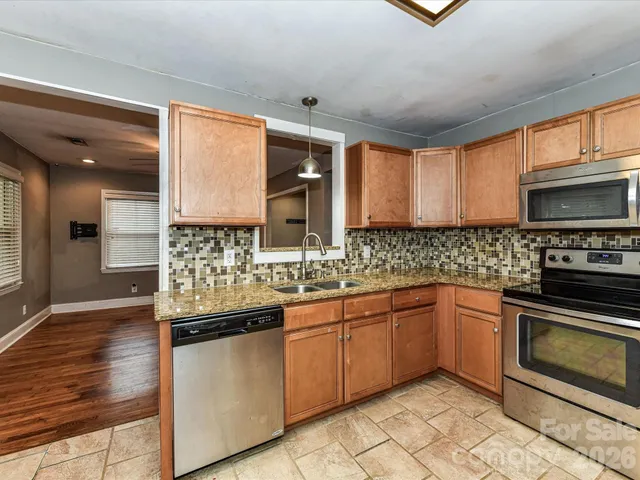 a kitchen with stainless steel appliances granite countertop a sink and cabinets