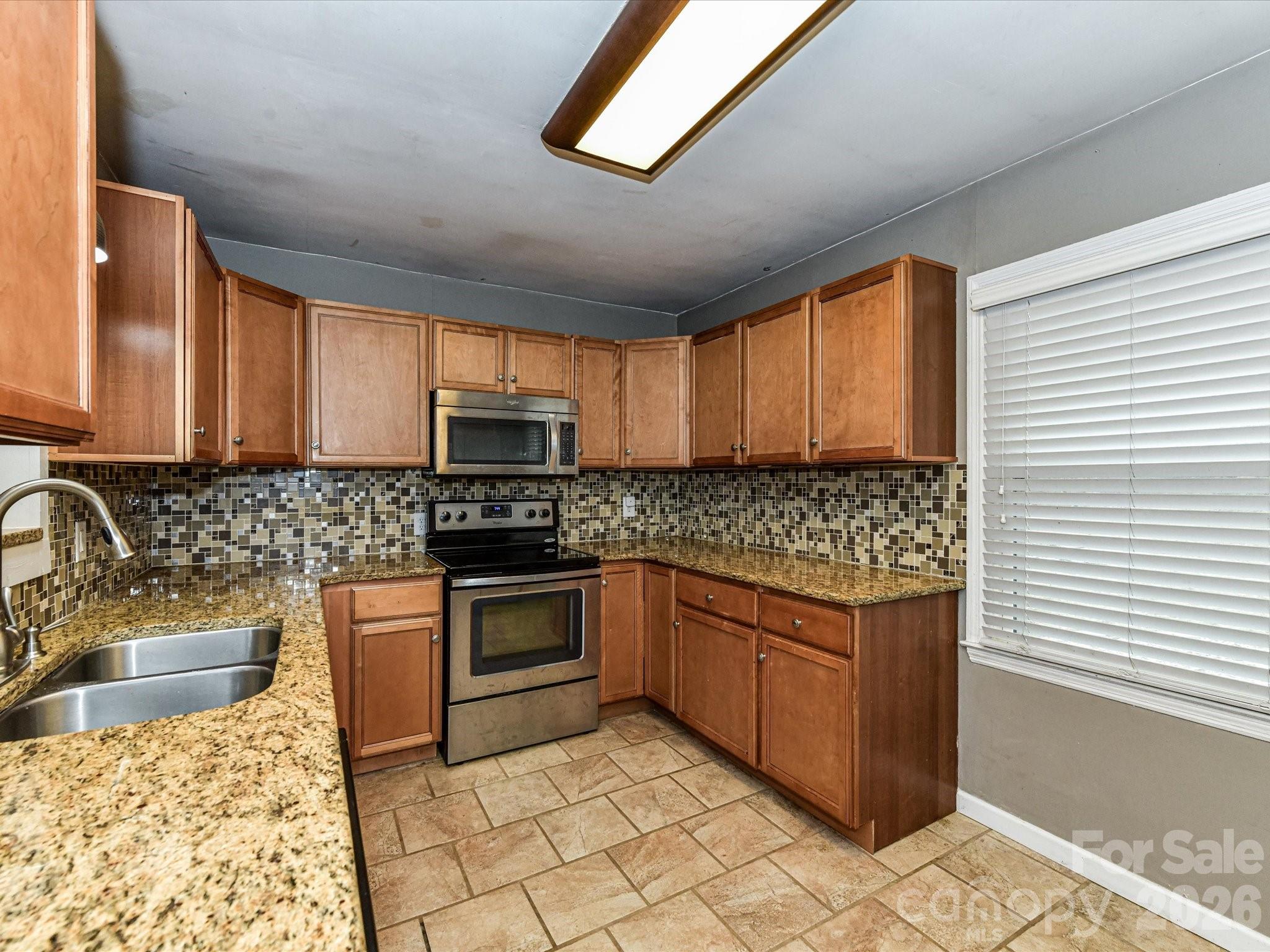 2303 Long Hope Road Monroe, NC 28112 - Photo 8 of 33 a kitchen with stainless steel appliances granite countertop a sink stove and cabinets