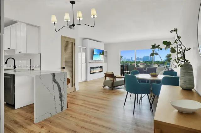 a living room with furniture a dining table and a chandelier