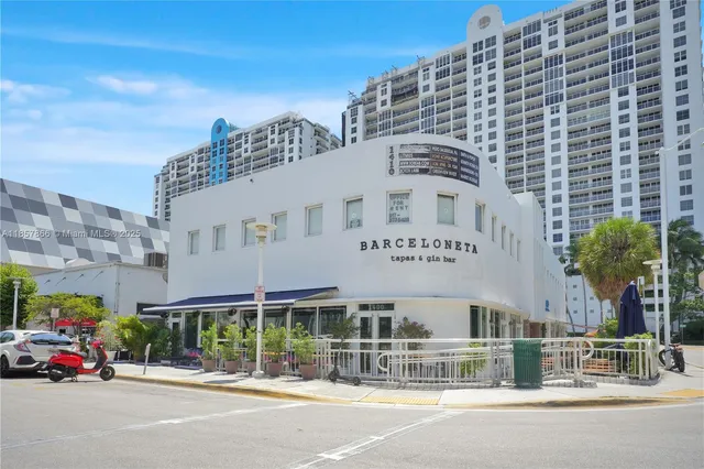 a front view of multi story residential apartment building with yard and outdoor seating
