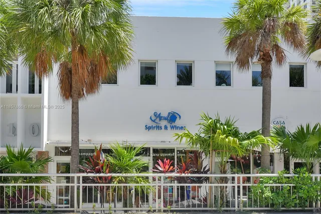 a blue and white building with a large windows and a yard