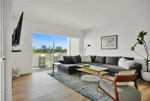 a living room with furniture a rug and a kitchen view