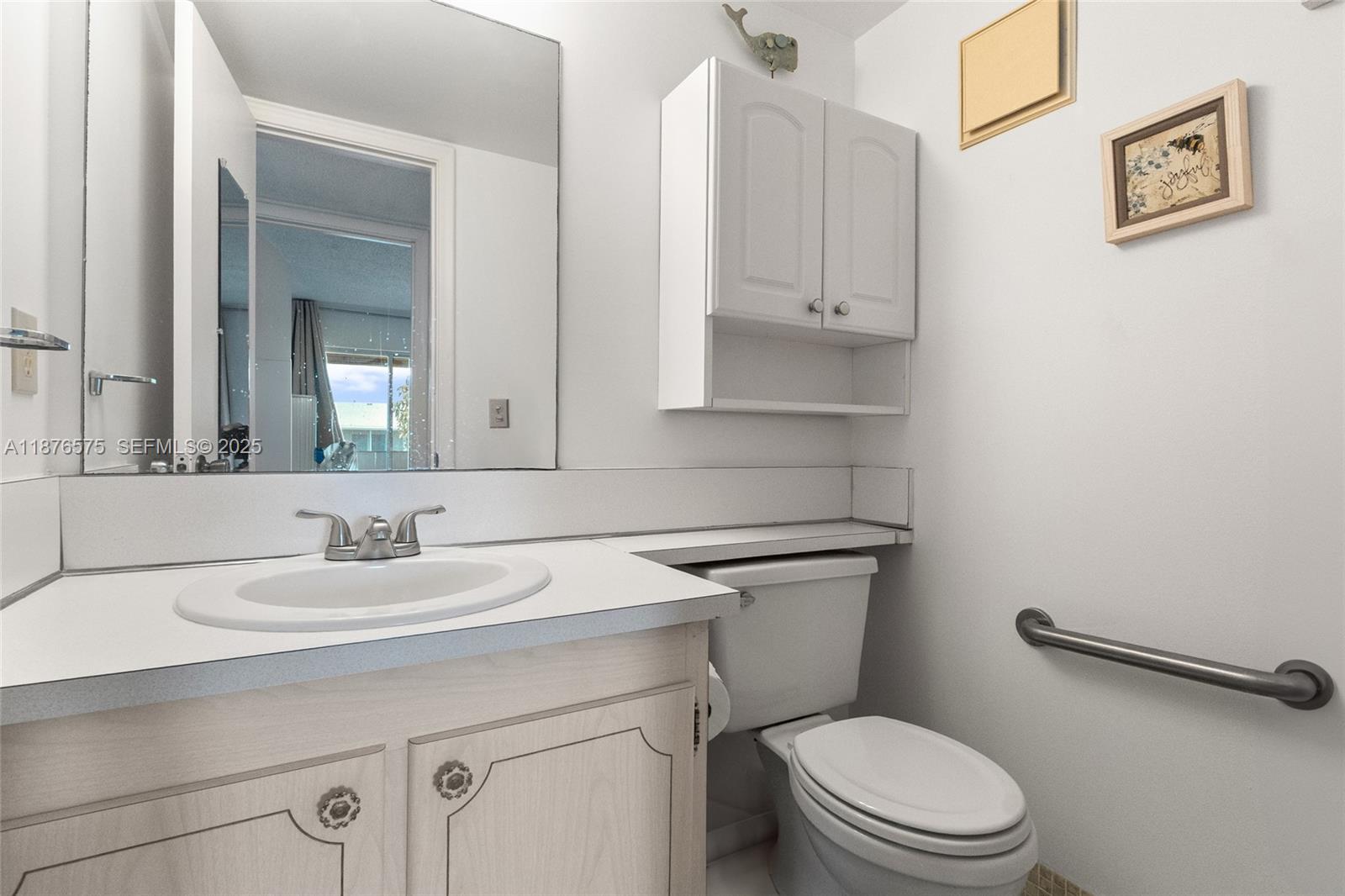 431 Markham South, Unit 431 Deerfield Beach, FL 33442 - Photo 15 of 30 a bathroom with a toilet sink and mirror
