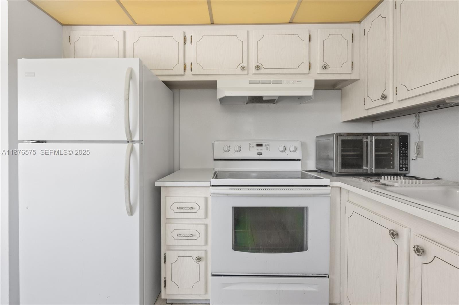 431 Markham South, Unit 431 Deerfield Beach, FL 33442 - Photo 16 of 30 a kitchen with stainless steel appliances white cabinets and a refrigerator