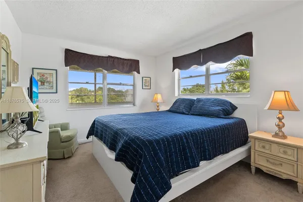 a bedroom with a bed dresser and window