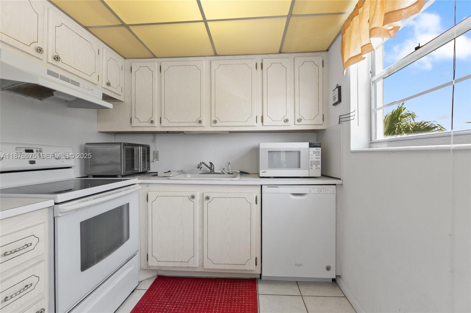 431 Markham South, Unit 431 Deerfield Beach, FL 33442 - Photo 6 of 30 a kitchen with white cabinets and white appliances