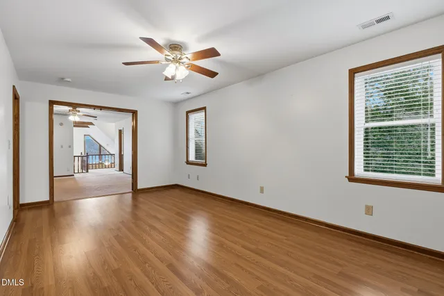 an empty room with wooden floor and entrance