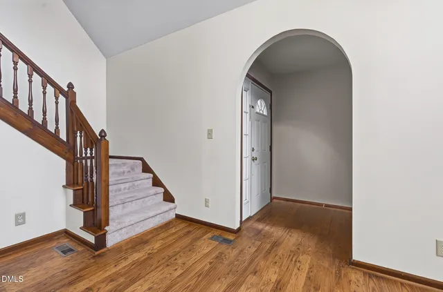 a view of a hallway with wooden floor and staircase