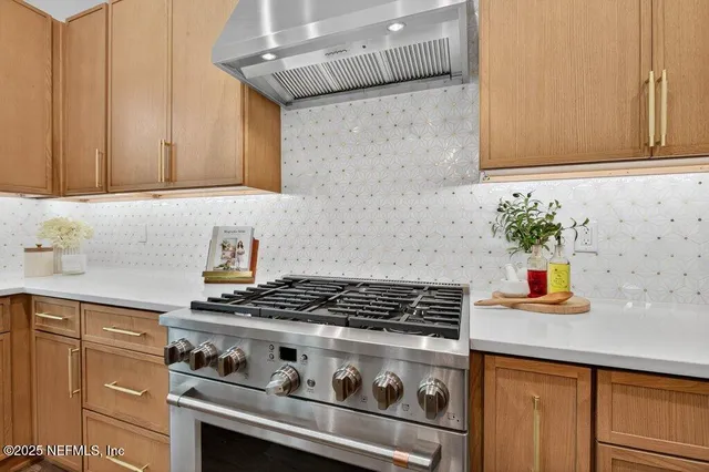 a kitchen with stainless steel appliances granite countertop white cabinets sink and a granite counter top