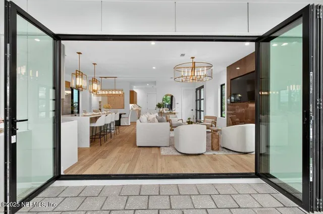 a living room with furniture a chandelier and a large window